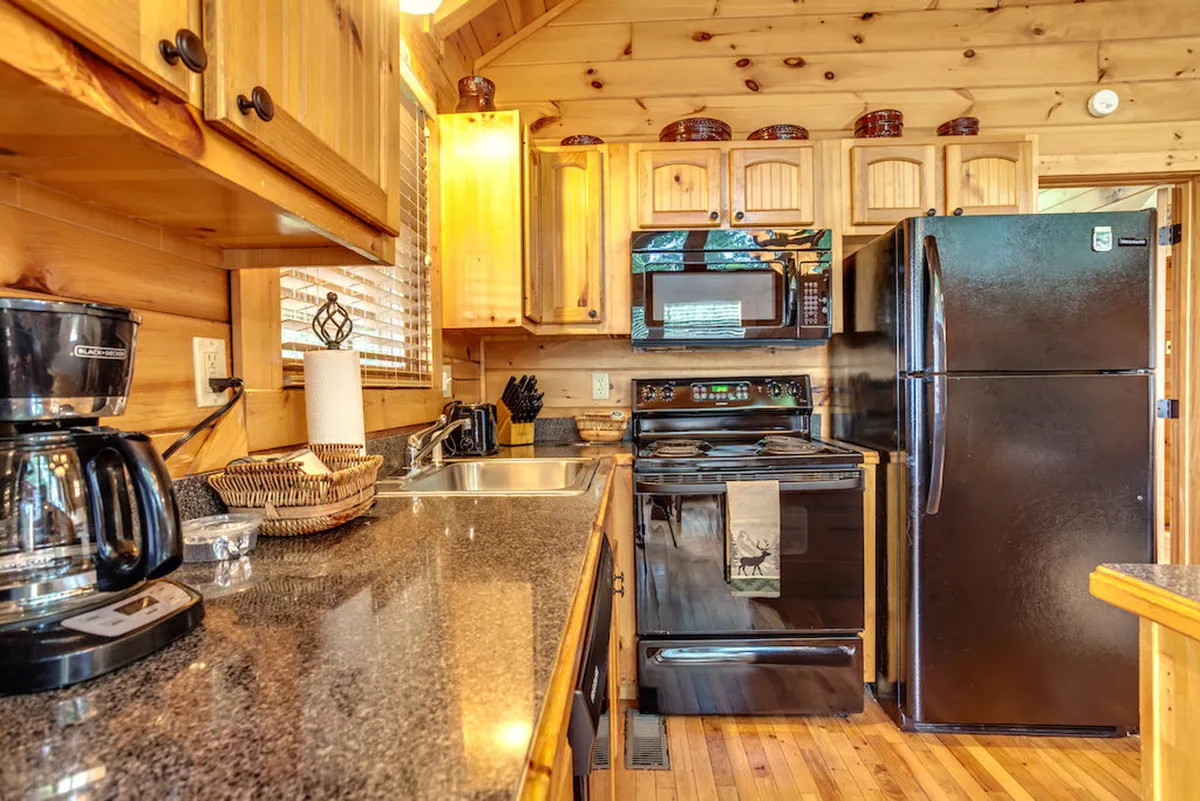 The kitchen features granite countertops, modern appliances, and wooden cabinets, exuding warmth and functionality. The space is ready for collaborative meal prep, morning coffee, or spontaneous snacks with friends and family.